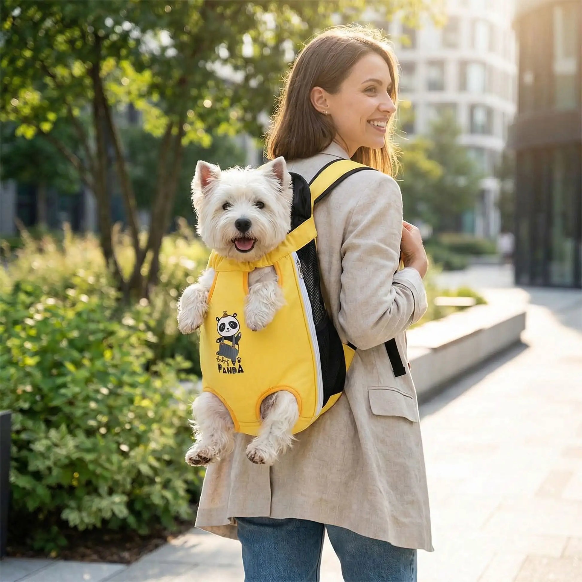 Une femme vue de dos marche sur un trottoir, porte son west highland dans son sac à dos pour transporter un chien panda.