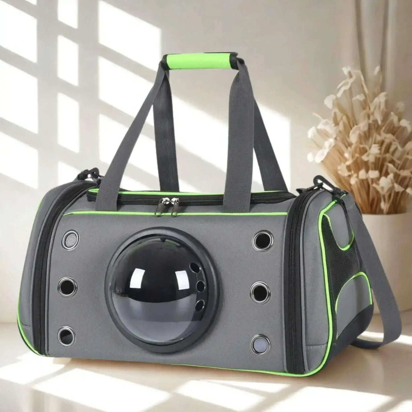 Un sac de transport pour chien gris et vert fluo sur une surface blanche, avec un vase de fleurs en arrière.