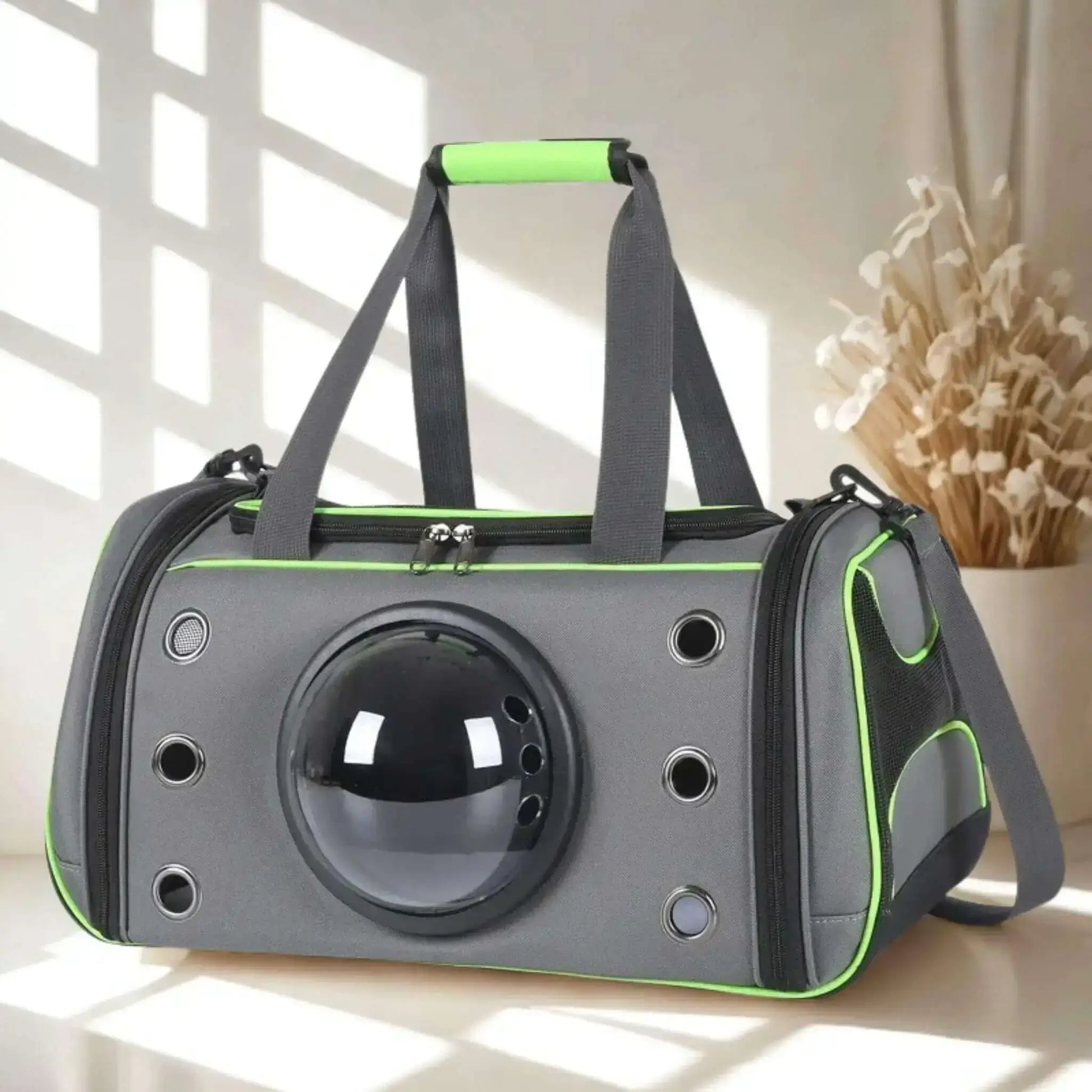 Un sac de transport pour chien gris et vert fluo sur une surface blanche, avec un vase de fleurs en arrière.