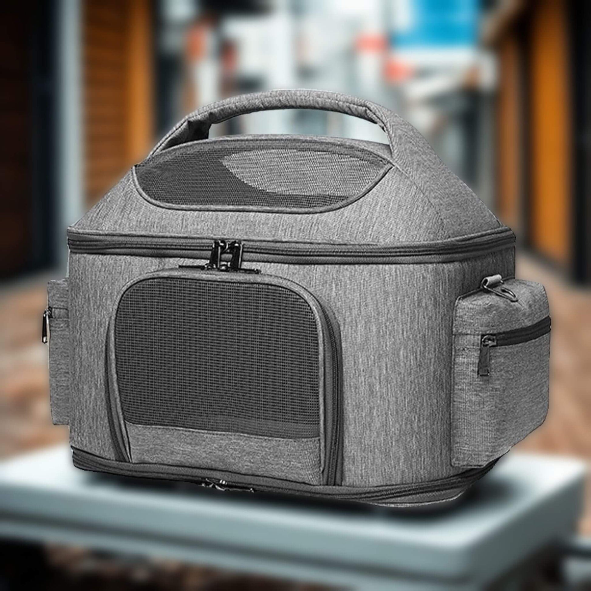 Un sac de transport pour chien gris équipé de maille respirante et de deux pochettes latérales