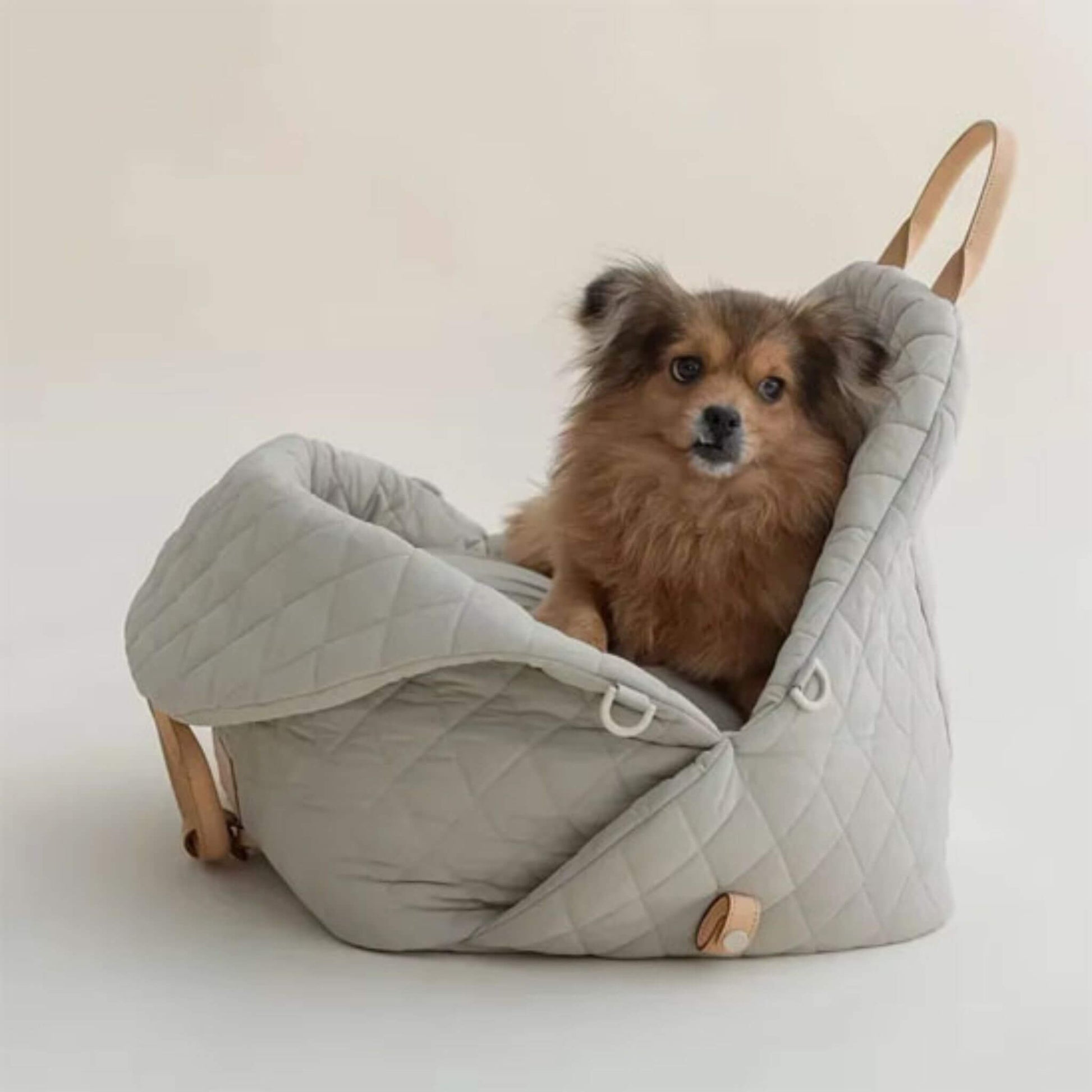 Sac de transport pour chien de couleur grise avec un pékinois couché dedans