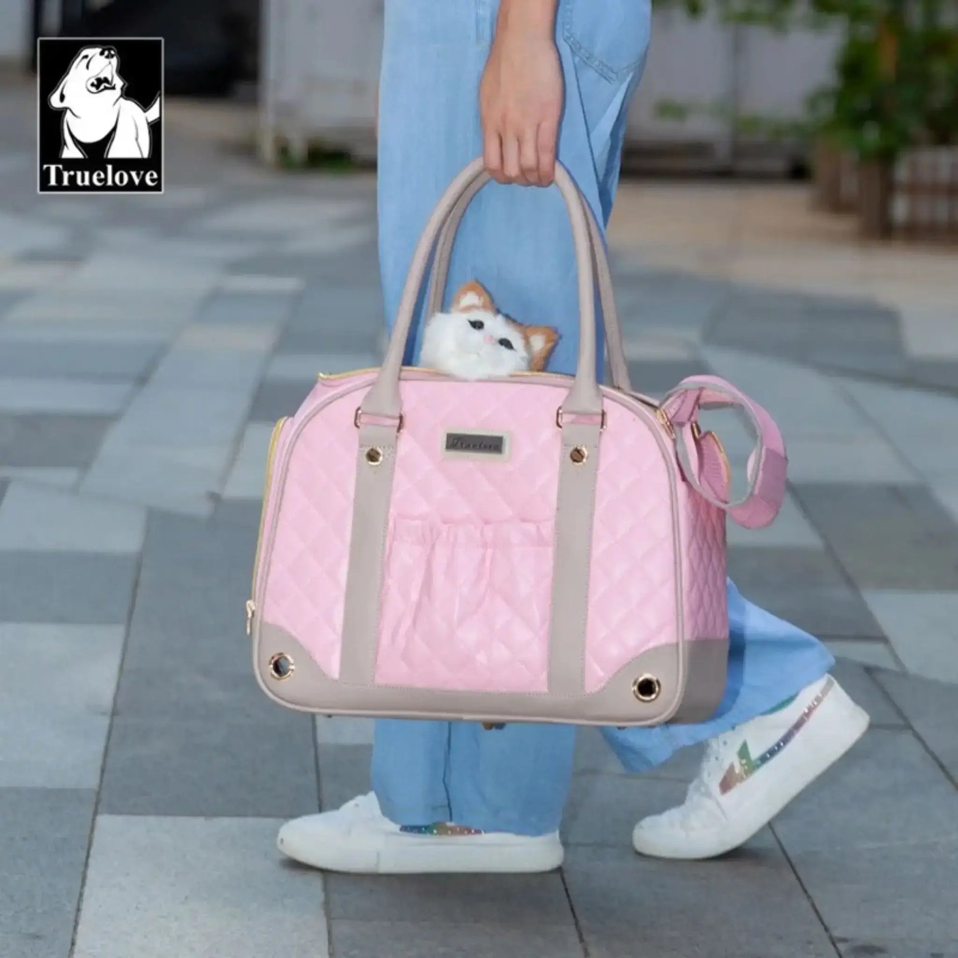 Une femme porte à la main un sac pour transporter un chien rose.