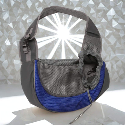 Un sac à bandoulière pour chien porté par un humain gris et bleu sur une surface blanche brillante