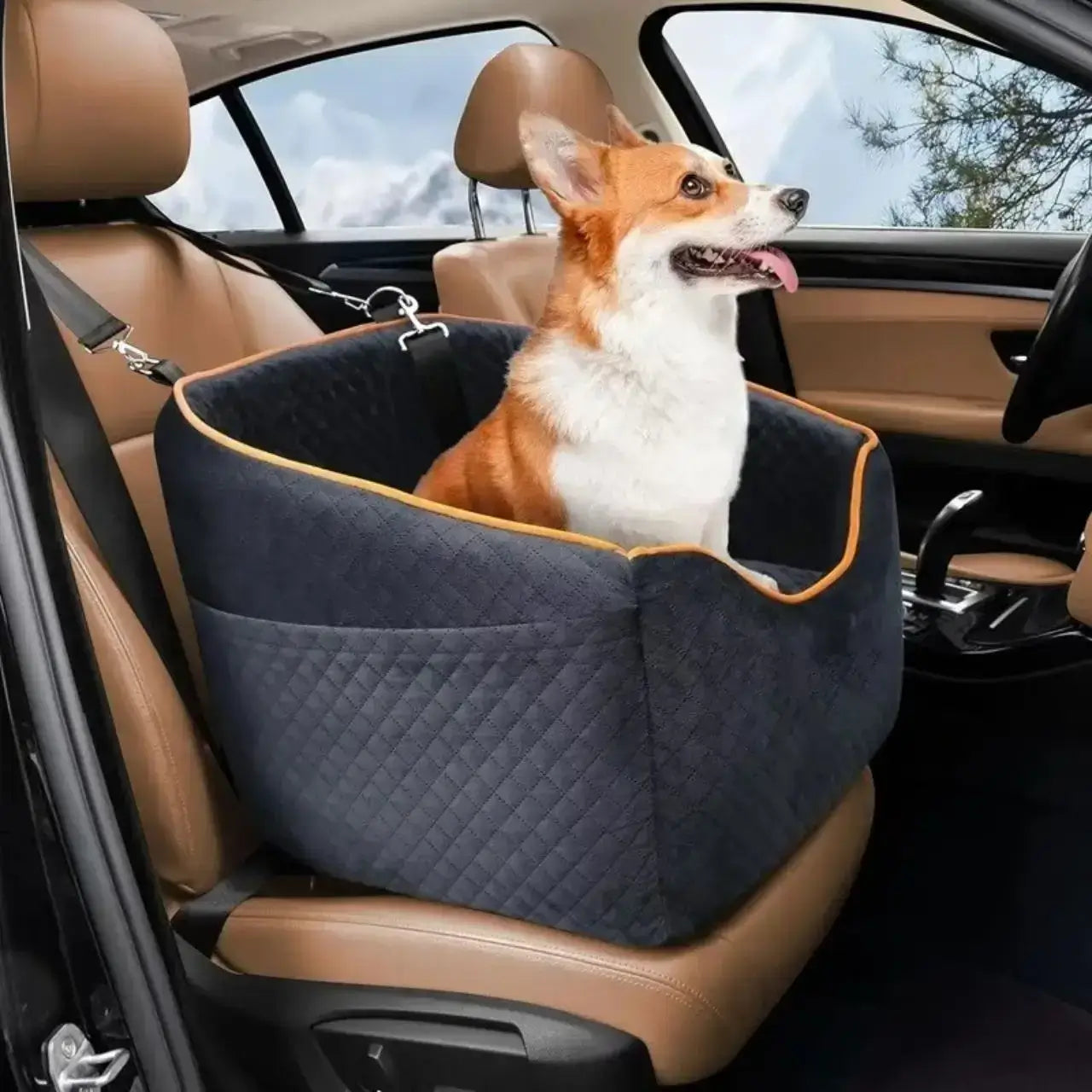 Un corgi assis dans son siège d'auto pour chien noir sur le siège avant de la voiture.