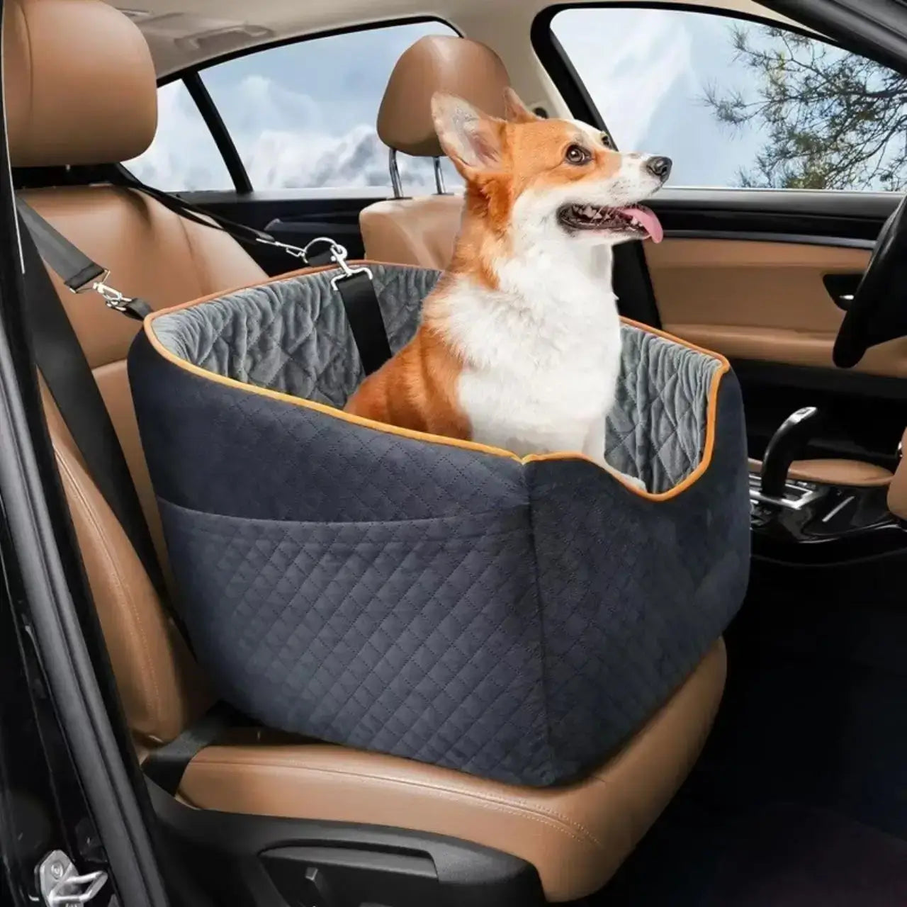 Un corgi assis dans son siège d'auto pour chien noir et gris sur le siège avant de la voiture.