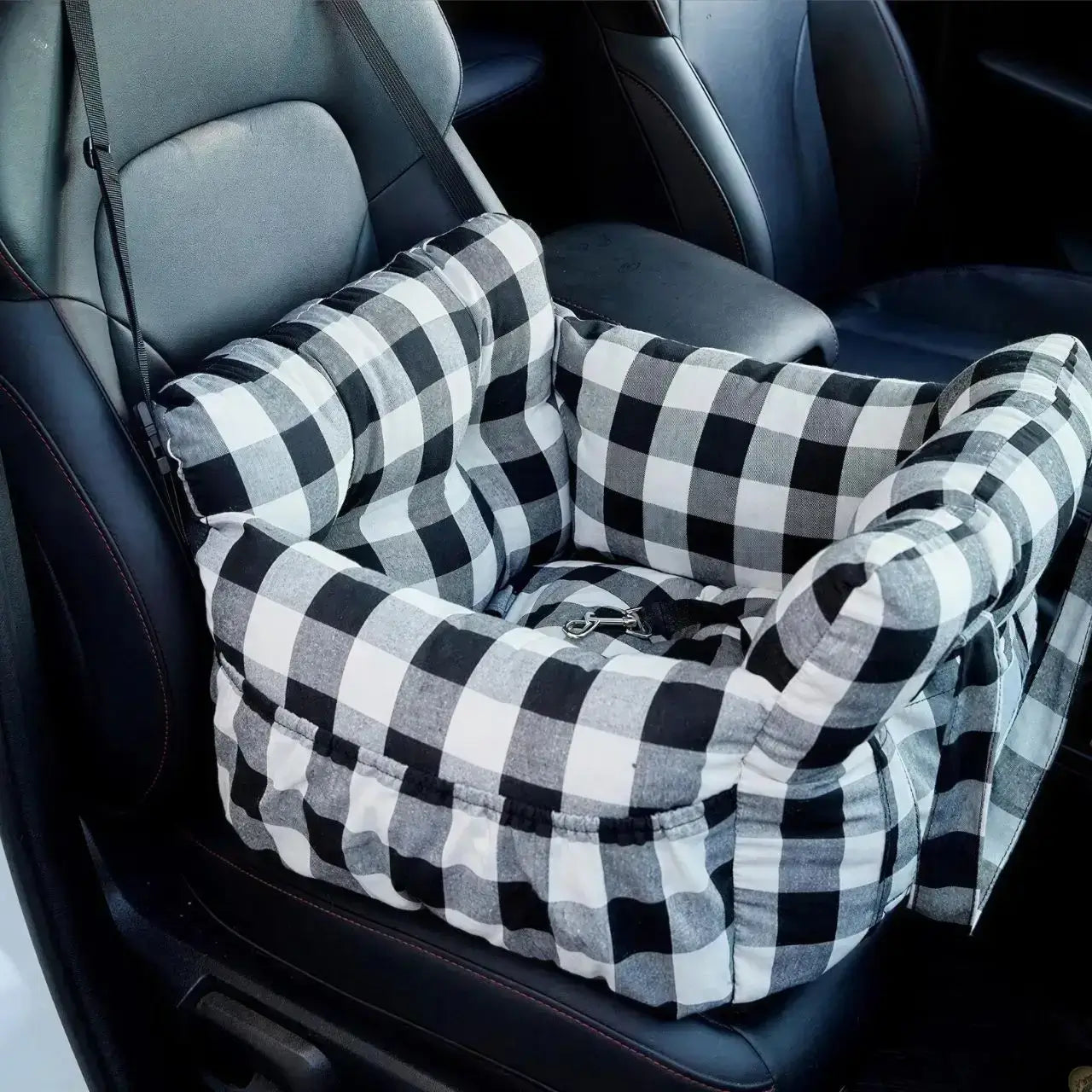 Un siège d'auto pour chiens à carreaux noir et blanc.