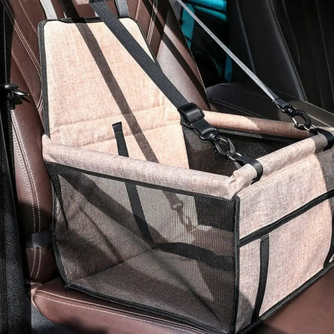 Un siège pour chien de voiture sur le siège avant de couleur beige.