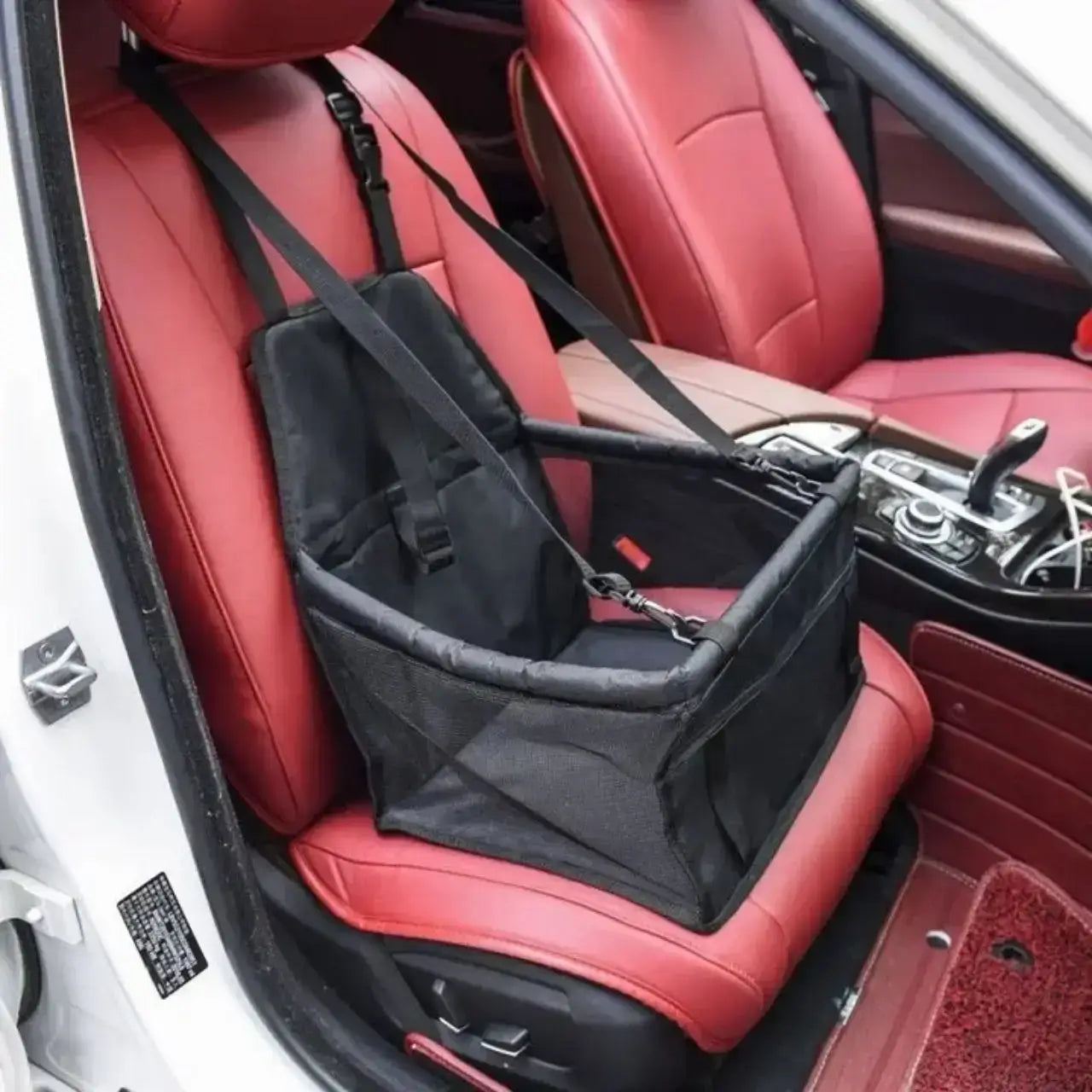 Un siège pour chien de voiture sur le siège avant de couleur noire.