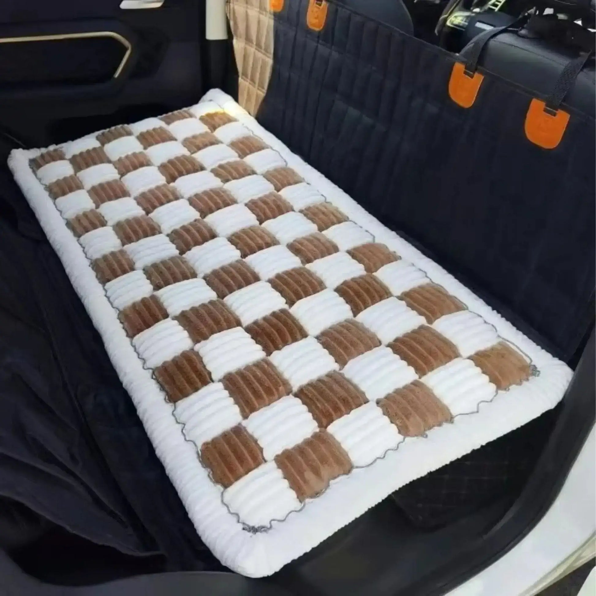 Un tapis pour chien de voiture beige et blanc sur le siège arrière d'une voiture.