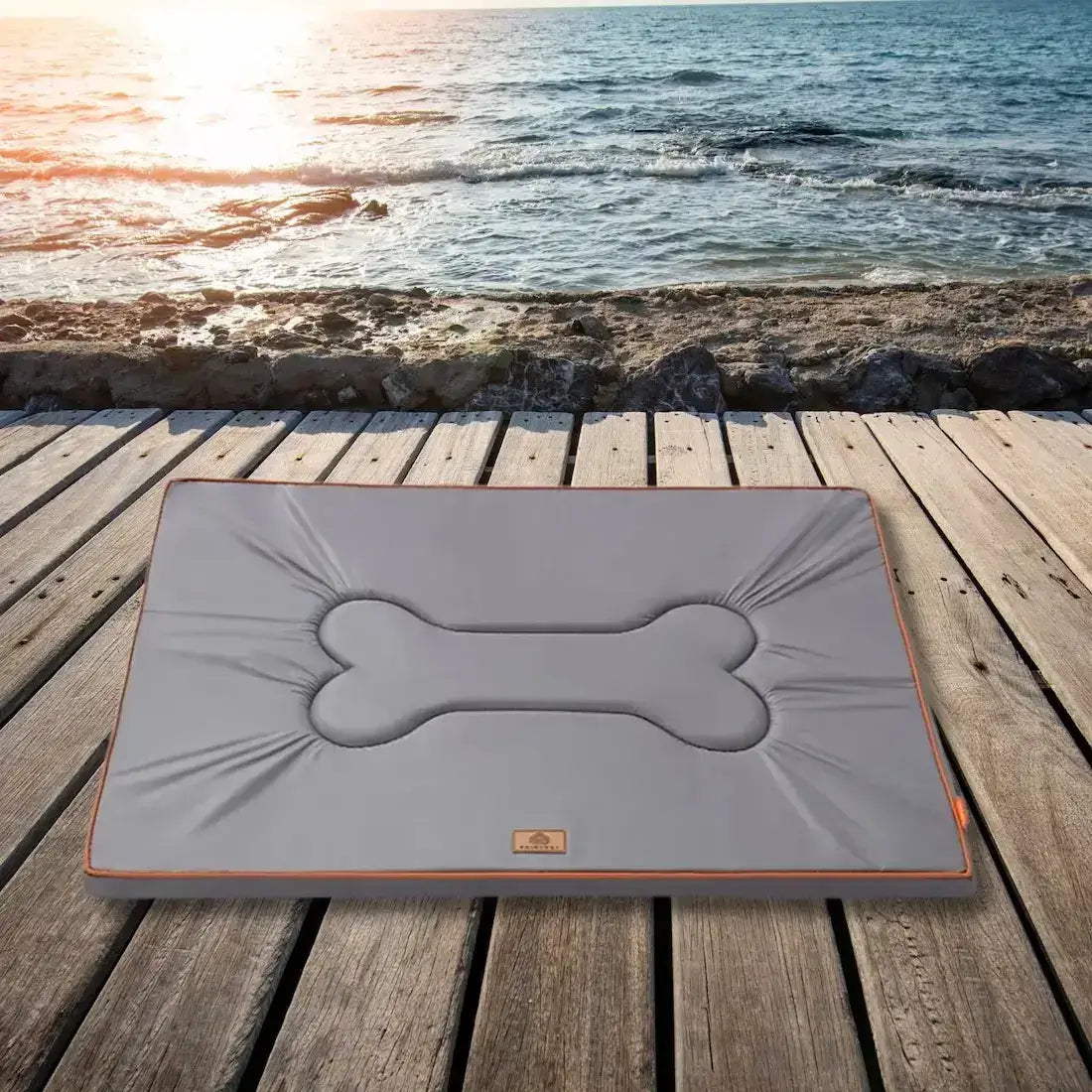 Un tapis imperméable pour chien gris sur un quai près de la mer.
