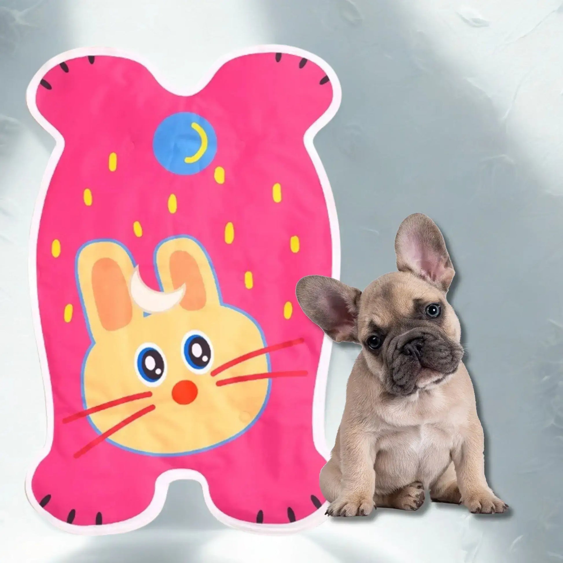 Un chiot bouledogue français avec un tapis rafraichissant pour chien de couleur rose avec motif lapin.
