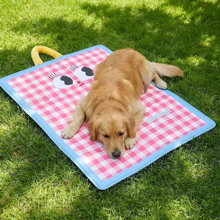 Un golden retriever allongé sur un tapis rafraichissant pour chiens sur une pelouse.
