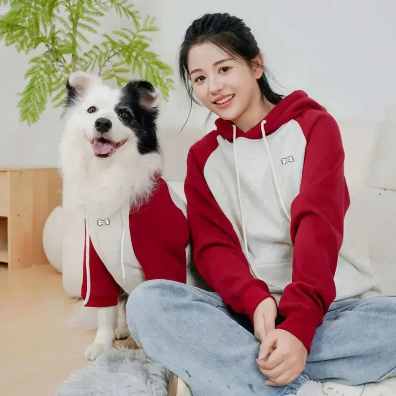Une femme assise avec son border collie est vêtue d'un vêtement pour chien assorti à sa maîtresse.